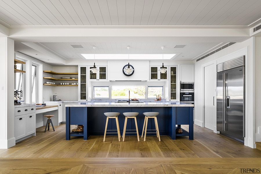 Classic shiplap finishes and Shaker-style cabinetry meet modern functionality in this seaside kitchen